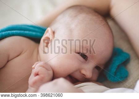 Happy Little Baby Lying Next To The Mother, Breastfeeding. Love Of Baby And Mom