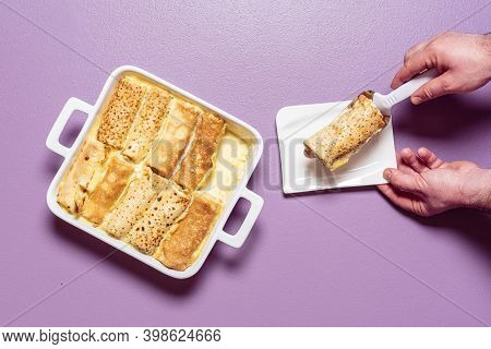 Man Hands Taking With A Spatula Stuffed Crepes From The Tray. French Pancakes Roll Filled With Sweet