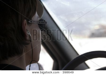 上一个女人开车将耳机与上关闭