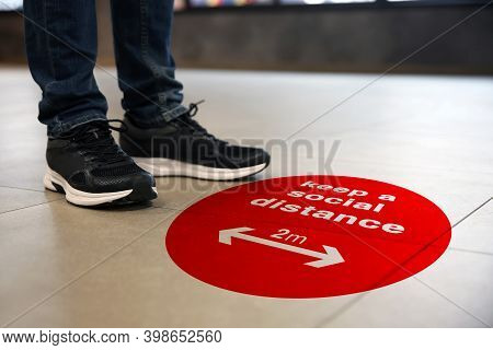 Keep Social Distance As Preventive Measure During Coronavirus Outbreak. Red Warning Sign On Floor In