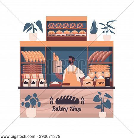 Male Baker Holding Bag With Baguettes Man In Uniform Selling Fresh Bakery Products In Baking Shop Po