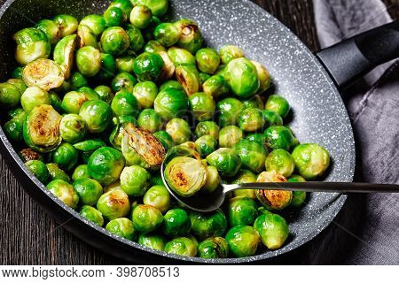 Brussels Sprouts Roasted With Garlic And Served On A Frying Pan On A Dark Wooden Background With Lin