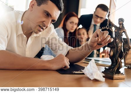 Frustrated Father In Suit Sits On Couch Next To Young Wife And Daughter. A Man Sits In A Suit And Lo