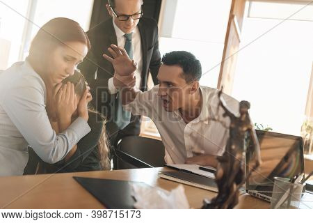 Frustrated Father In Suit Sits On Couch Next To Young Wife And Daughter. A Man Sits In A Suit And Lo
