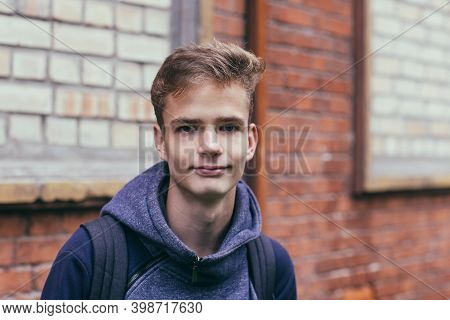 Portrait Of A Pretty Teenager Against A Brick Wall Background.