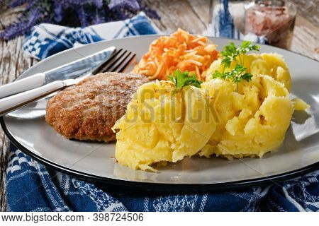 Homemade Minced Meat Cutlet Served With Mashed Potatoes And Carrot Salad.