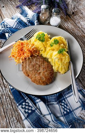 Homemade Minced Meat Cutlet Served With Mashed Potatoes And Carrot Salad.