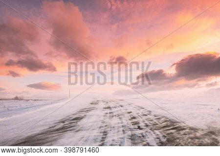 Snow-covered Open Slippy Road During A Snowstorm Blizzard In Winter. Altered Colorful Sunset Sunrise