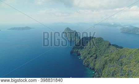 Asia mountainous isle with exotic nature variety scape. Tropical highland island aerial view at blue ocean bay. Cinematic summer scenery of Palawan islet, Philippines. Soft light drone shot