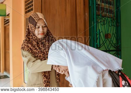 Portrait Of Islamic School Students Kissing The Teachers Hand