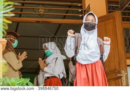 Portrait Of Students Saying Goodbye To Teachers With Social Distancing Protocols