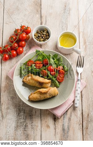 rolled sword fish with capers arugula and tomatoes salad