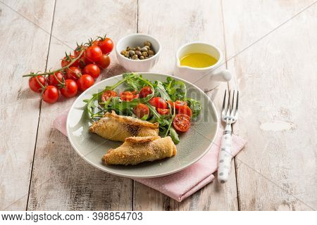 rolled sword fish with capers arugula and tomatoes salad