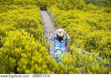 Asian Traveler Woman Holding The Hat And Standing On Wooden Bridge For Travel At Tung Prong Thong Fo