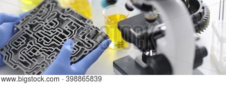 Automatic Transmission Lies In Rubber Gloves On Table With Microscope And Test Tubes In Chemical Lab