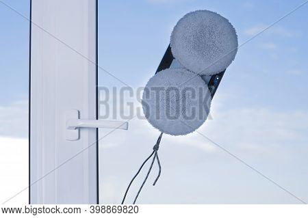 Downside Of Vacuum Cleaner Robot For Washing Glass Window On Clean Blue Sky. Domestic Robot Assistan