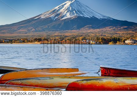 Majestic Fuji Mountain Near Lake Kawaguchiko In Japan With Line Of Overthrown Boats In Foreground. A