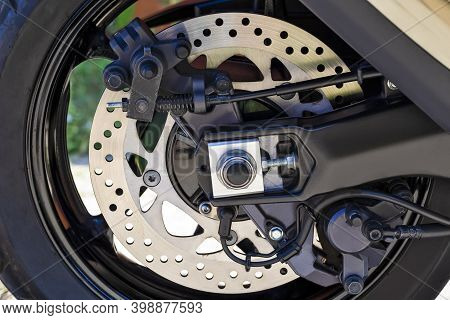 Motorcycling Ideas. Closeup Shoot Of Moto Rear Wheel Brake Disk With Abs Sensor And Brake Pistons.