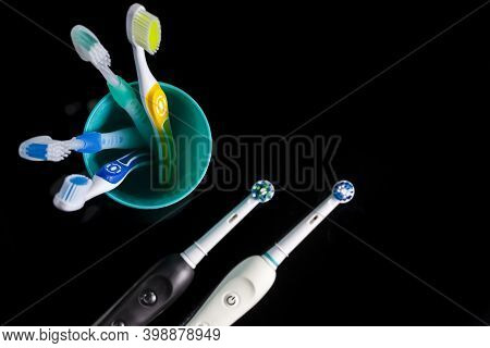 Oral Care Ideas. Pair Of Professional Electric Toothbrushes In Front Of Four Manual Toothbrushes Pla