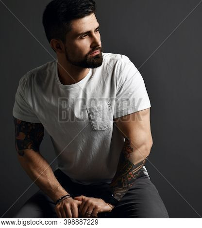 Portrait Of Handsome Modern Brutal Bearded Muscular Man In T-shirt And Jeans And With Tattoo On Arms