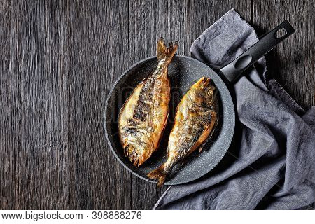 Grilled Sea Bream, Orata, Dorado Fish In A Skillet On A Dark Wooden Table, Horizontal View From Abov