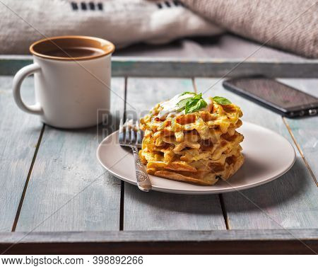 Omemade Zucchini Waffles In A Stack On A Light Plate With Cheese Sauce, Coffee In A Large Beige Mug
