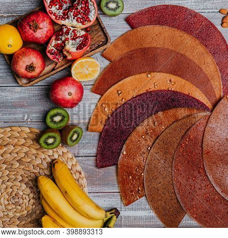 Many Colorful Fruit Leathers With Fresh Fruits On The Wooden Table. Round Fruit Leather. Healthy Foo