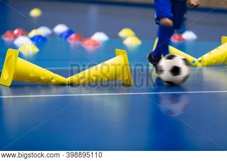 Futsal Young Player Running Ball On Training Pitch. Wooden Indoor Soccer Floor. Yellow Training Cone