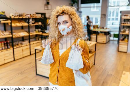 Blond Curly Woman In Reusable Protective Face Mask Using Textile Bag On Plastic Free Grocery Store O