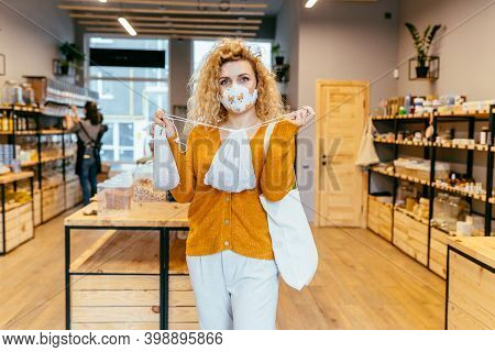 Blond Curly Woman In Reusable Protective Face Mask Using Textile Bag On Plastic Free Grocery Store O