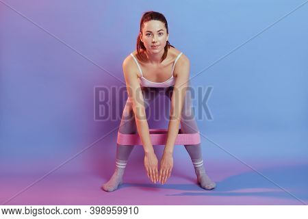 Sportswoman Performs Exercises With Resistance Band, Leaning Body Forward, Using Resistance Rubber B