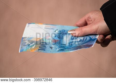 World Money Concept, Close Up Of 100 Swiss Franc Banknote, Photo Of Chf Currency Isolated. Hand Hold