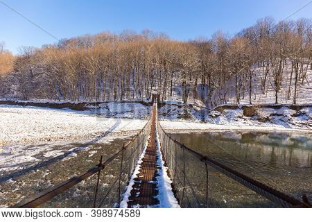 Suspention Bridge Over The Mountain River Winter View.