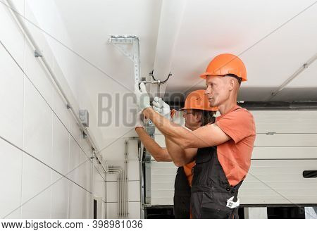 Workers Are Installing Lift Gates In The Garage.