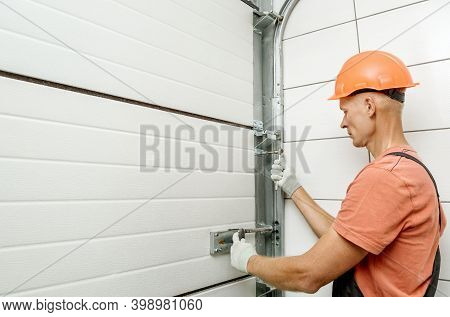 The Worker Is Installing Lift Gates In The Garage.