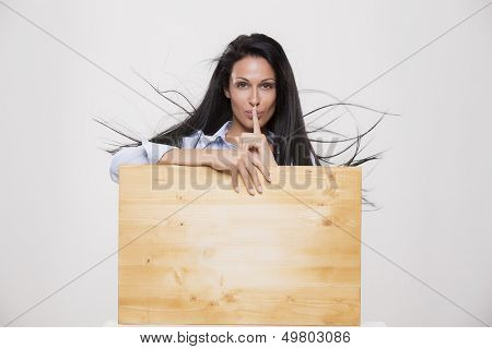 Beautiful woman with blank parole background ask for silence