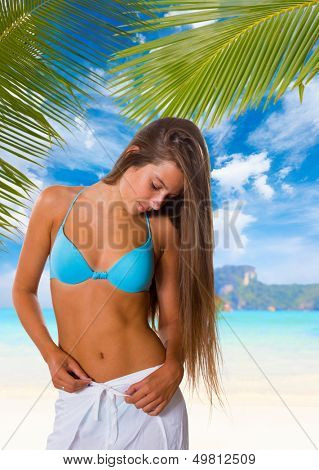 Young woman reaxing on the beach at exotic resort
