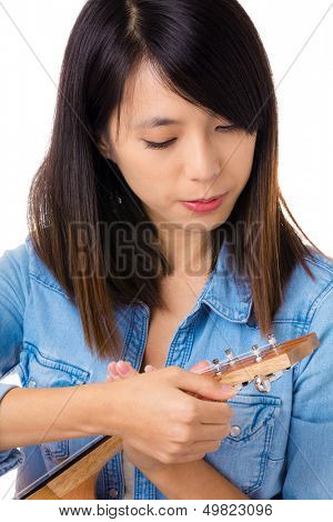 Asian woman tunning ukelele