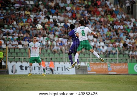 KAPOSVAR, HUNGARY - AUGUST 16: Stjepan Babic (in white) in action at a Hungarian National Championship soccer game - Kaposvar (white) vs Ujpesti TE (purple) on August 16, 2013 in Kaposvar, Hungary.