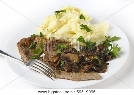 Fried escalope of veal served with mashed potatoes and a creamy mushroom sauce