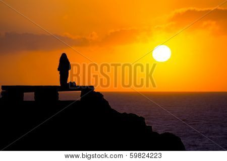Ciutadella Menorca at Punta Nati orange sunset with girl backlight