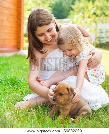Cute Little Girl And Her Mother Hugging Dog Puppies