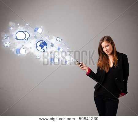 Pretty young girl holding a phone with social media icons in abstract cloud