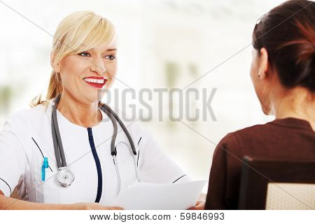 Mature female doctor talking with her patient. 