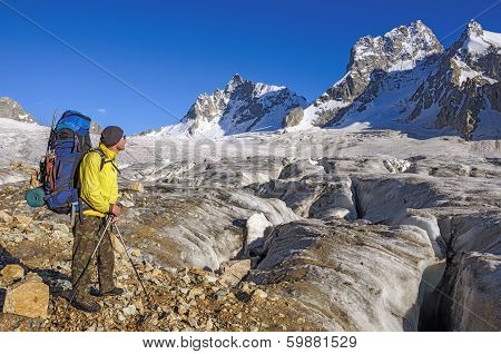 Hiker with a backpack on a glacier in the mountains of Georgia