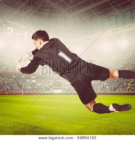 soccer or football goalkeeper is catching ball on stadium, warm colors toned