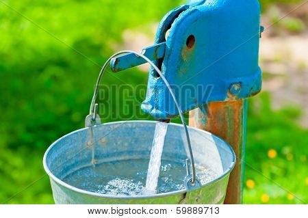 Old Rusty Wheel And A Bucket Of Clean Water