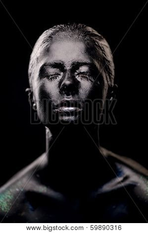 girl in black paint on dark background