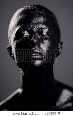 girl in black paint on dark background