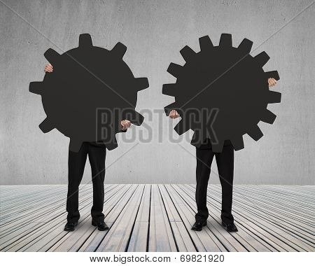 Businessmen Hold Their Different Gear On Wooden Floor